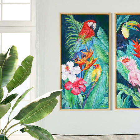 Tableau sur toile de déco murale jungle et nature au paysage exotique d’animaux sauvages représentant un couple d’oiseaux de perroquets : Ara Macao rouge et la perruche du soleil ou conure dans la jungle avec une végétation de feuilles de palmiers et d’hibiscus blancs et roses pour une ambiance jungalow et moderne