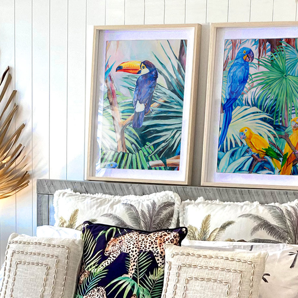 Tableau tropical et nature d’un toucan toco dans la jungle amazonienne entre les feuilles de palmiers vertes et bleus multicolores : une peinture d’oiseau sauvage pour une décoration moderne et contemporaine, végétale